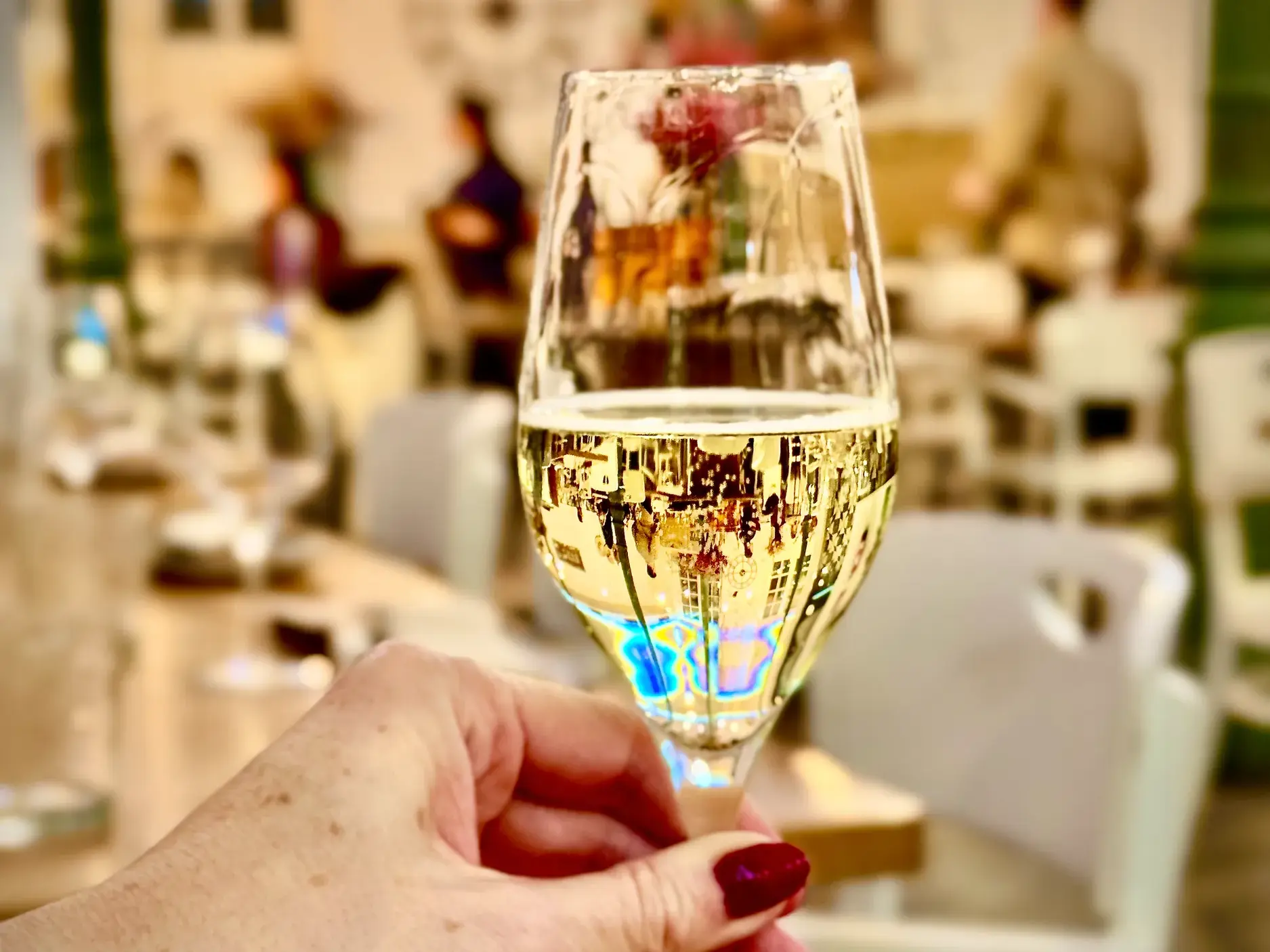 Eine Frau stößt bei einer Singlereise an Silvester in Madrid mit einem Glas prickelndem Cava auf das neue Jahr an.