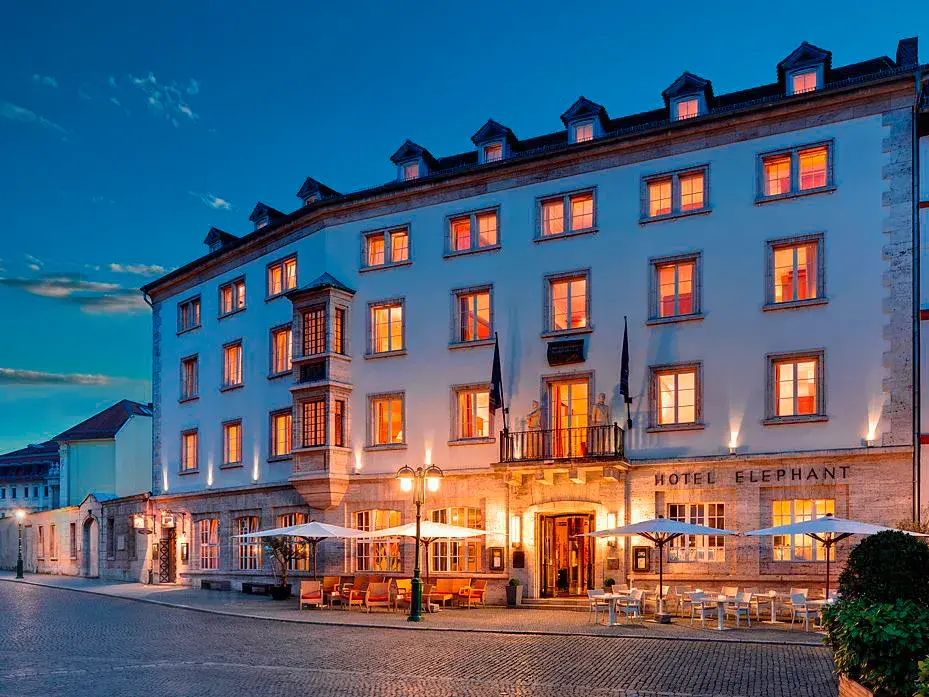 Beleuchtete Fassade des historischen Hotel Elephant am Marktplatz in Weimar zur Abenddämmerung.