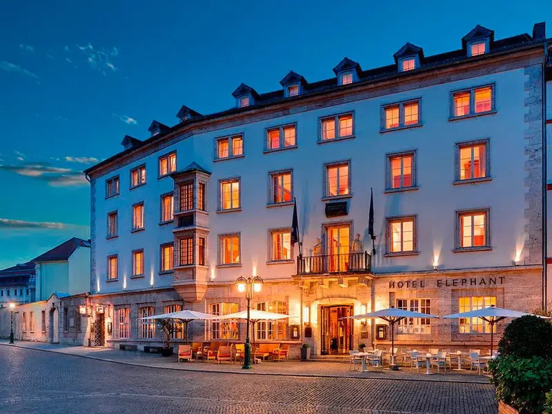 Beleuchtete Fassade des historischen Hotel Elephant am Marktplatz in Weimar zur Abenddämmerung.