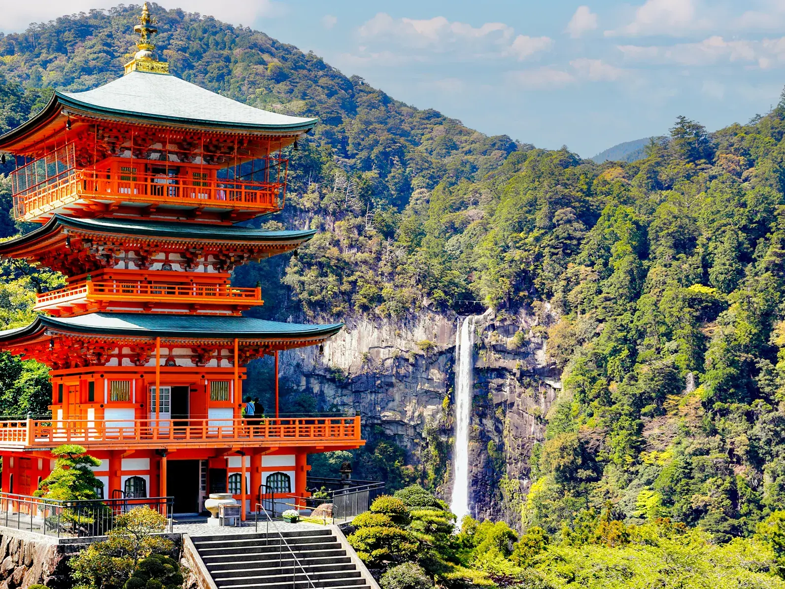 Die rote Seiganto-ji Pagode am Pilgerweg Kumano Kodo mit Blick auf den mächtigen Nachi Wasserfall in Japan.