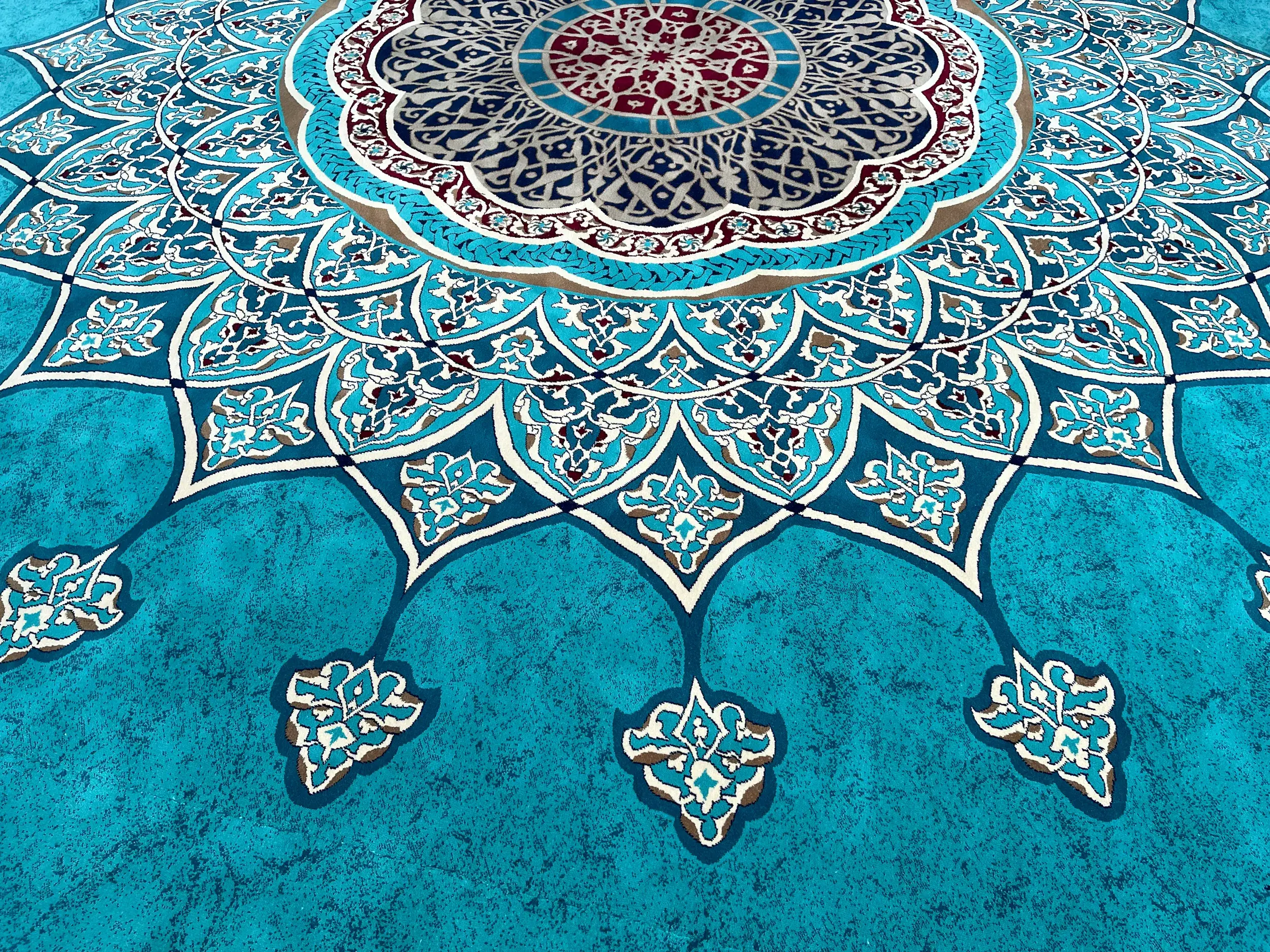 Detailaufnahme eines kunstvollen türkischen Teppichs mit orientalischem Muster in leuchtenden Türkis- und Blautönen.