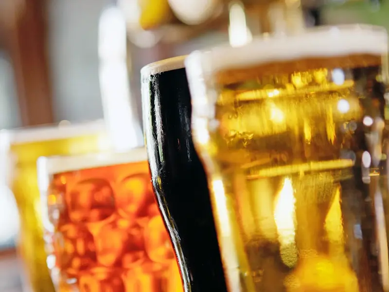 Verschiedene britische Biersorten in Gläsern auf dem Tresen eines gemütlichen Gastro-Pubs in London.