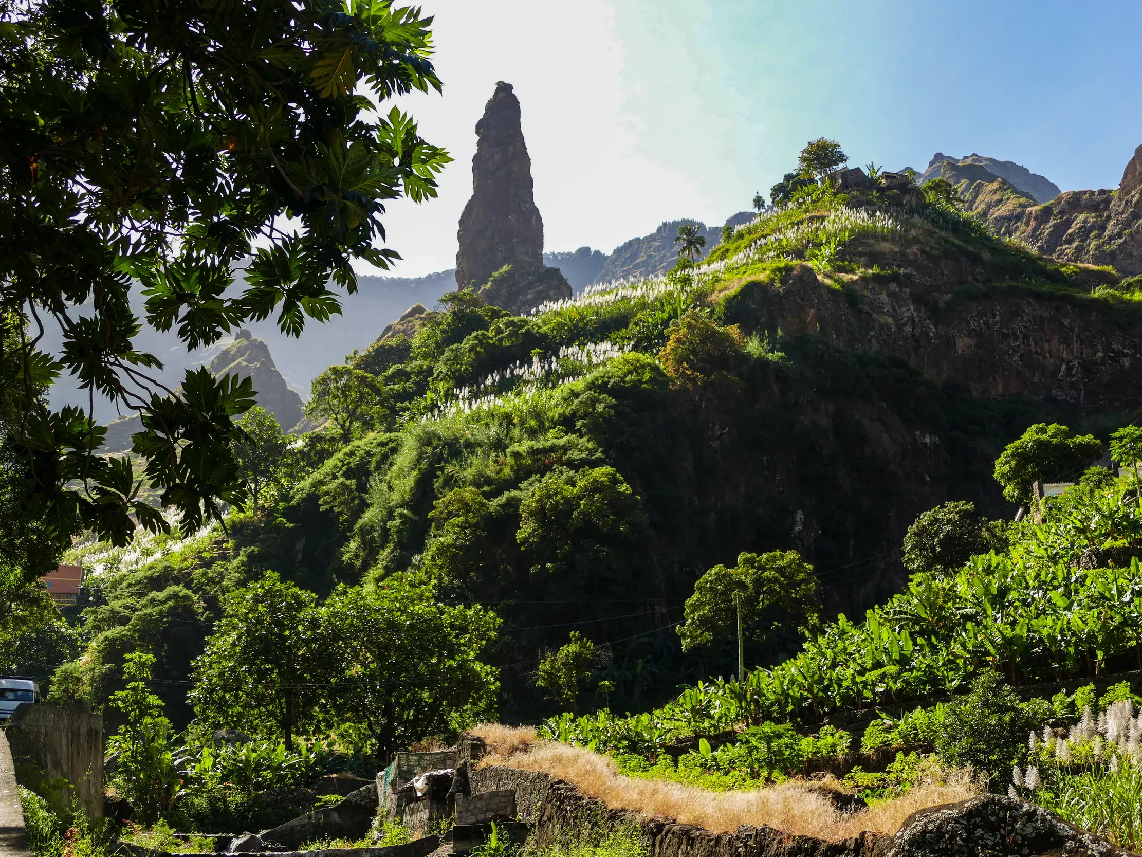 Wanderung durch das grüne Paul-Tal auf Santo Antão mit Blick auf die Felsnadel und üppige, terrassierte Vegetation.