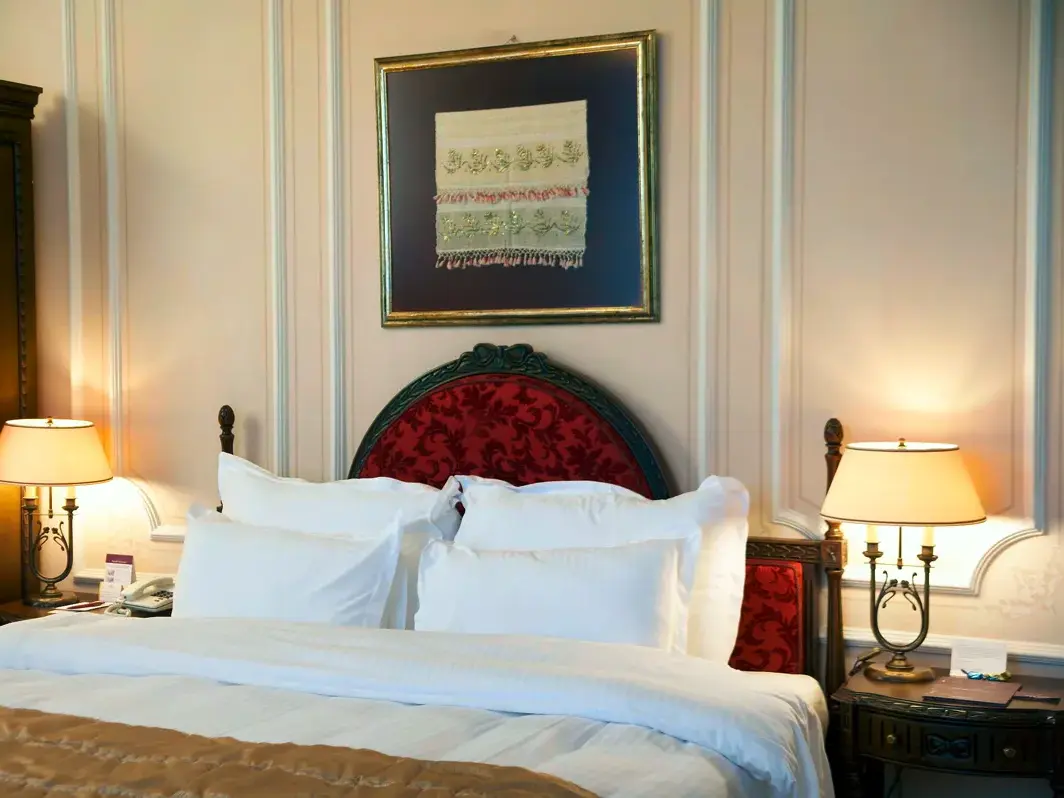 Stilvoll eingerichtetes Doppelzimmer im Hotel Anemon Galata in Istanbul mit rotem Kopfteil und warm beleuchteten Nachttischlampen.