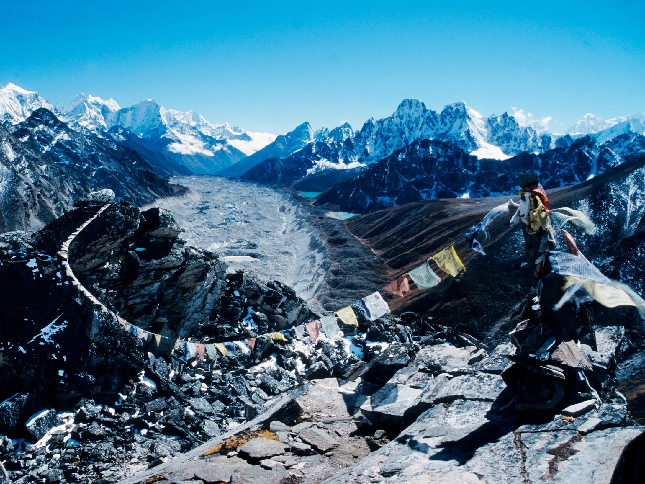 Gebetsfahnen am Renjo La Pass in Nepal mit Panoramablick über den Ngozumpa-Gletscher und die Gipfel des Himalaya.