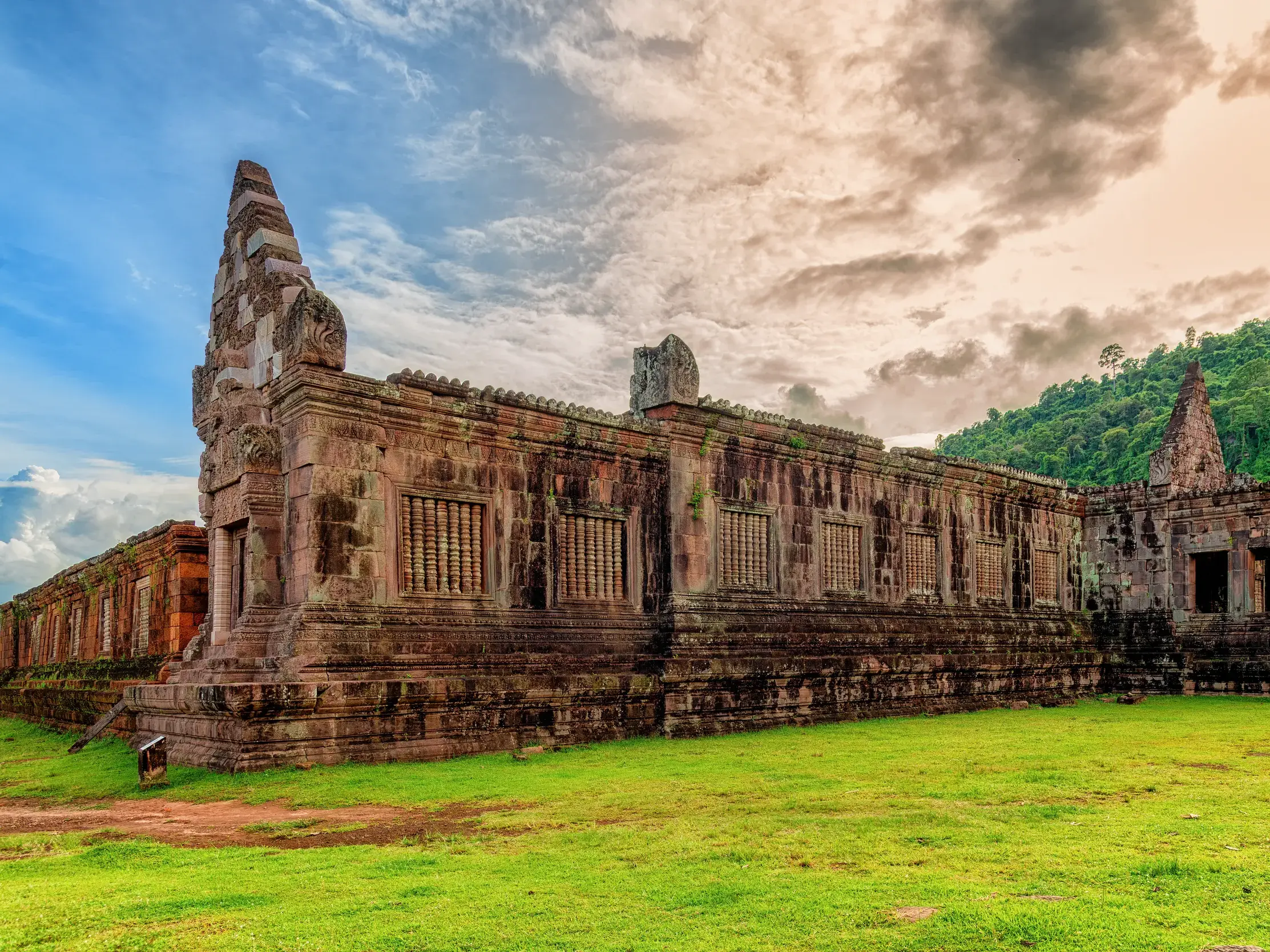 Die ehrwürdigen Ruinen des Khmer-Heiligtums Wat Phou in Laos, gelegen auf einer Wiese am Fuße des heiligen Berges Phu Khao.