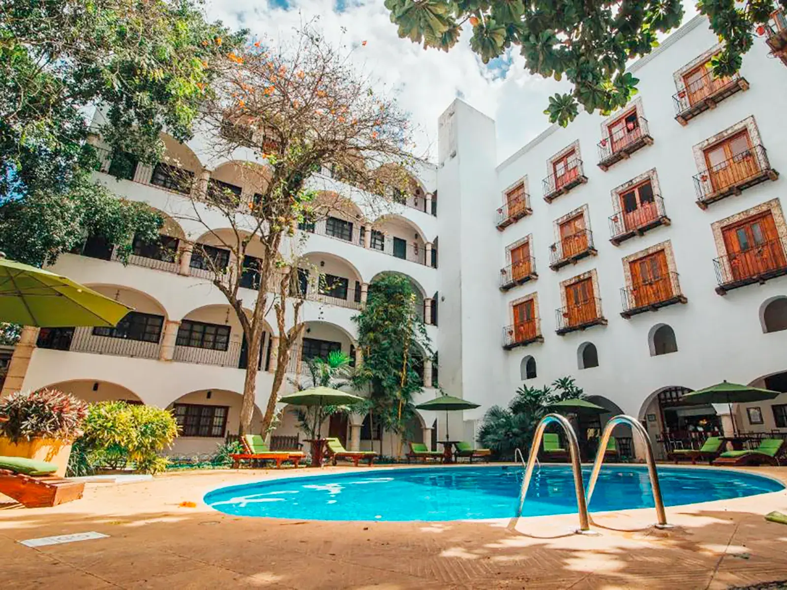 Sonniger Hotelpool im Innenhof des historischen Hotels El Mesón del Marqués in der Kolonialperle Valladolid in Mexiko.