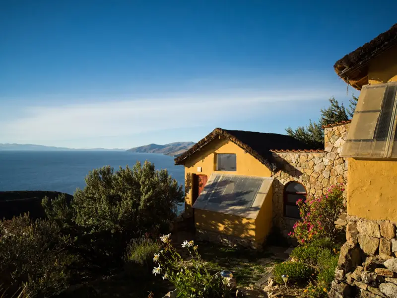 Ockerfarbene Gebäude der nachhaltigen Ecolodge La Estancia auf der Sonneninsel mit weitem Blick über den Titicacasee.