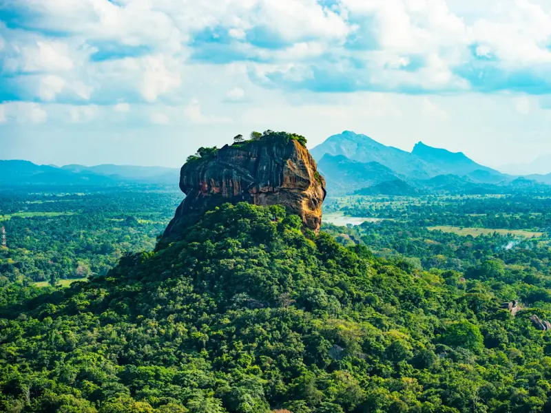 Panoramablick auf den berühmten Löwenfelsen Sigiriya, der majestätisch aus dem dichten, grünen Dschungel Sri Lankas emporragt.