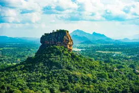Panoramablick auf den berühmten Löwenfelsen Sigiriya, der majestätisch aus dem dichten, grünen Dschungel Sri Lankas emporragt.