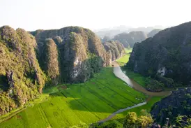 Spektakuläre Aussicht vom Ngoa Long Berg auf Reisfelder und den Ngo Dong Fluss in der trockenen Halong Bucht bei Tam Coc.