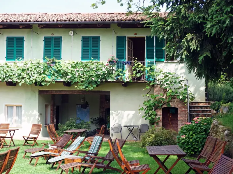 Ein bewachsenes Agriturismo in der Langhe lädt mit Liegestühlen im Garten zur Entspannung nach einer Trekking-Etappe ein.