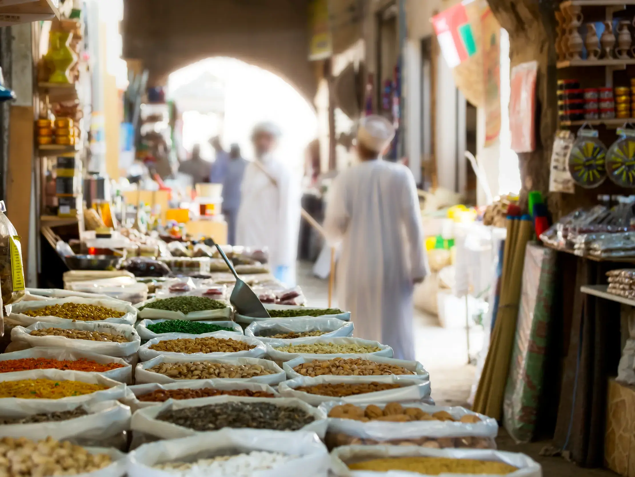 Farbenprächtige Gewürze in offenen Säcken auf einem Marktstand im Souk von Muttrah in Maskat, Oman.