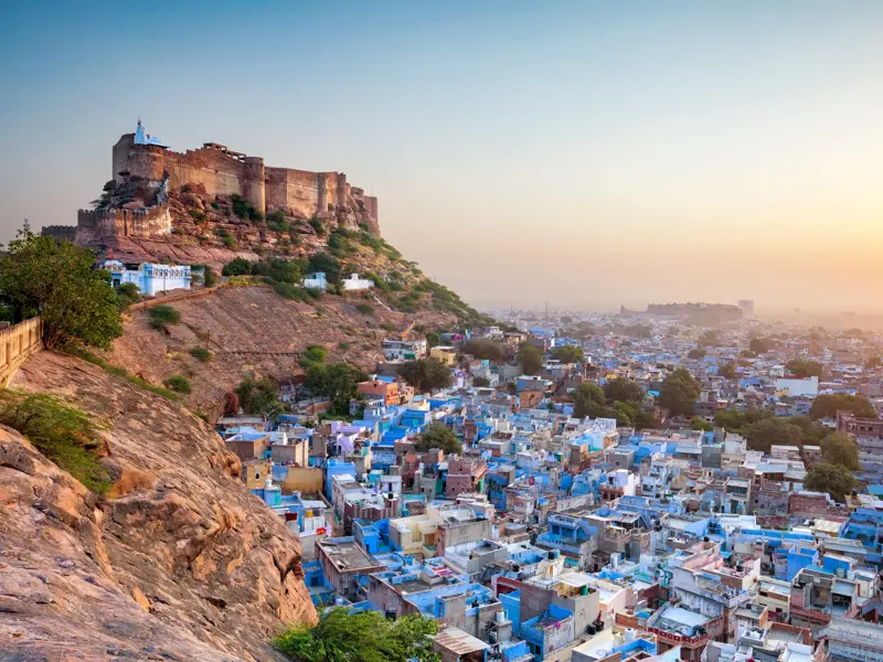 Majestätisches Mehrangarh Fort thront bei Sonnenaufgang über den blauen Dächern der Altstadt von Jodhpur in Rajasthan.