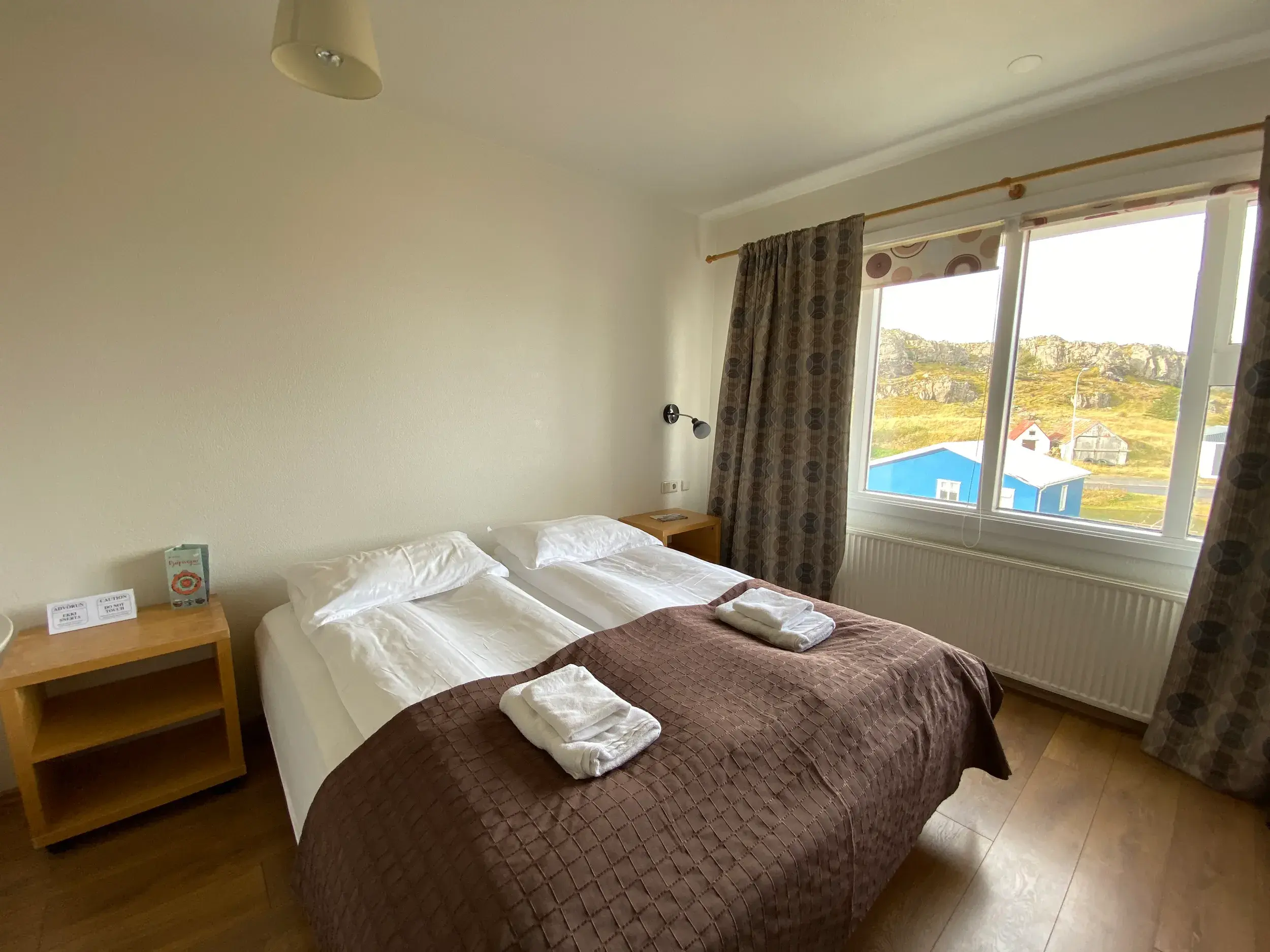 Doppelzimmer in einem typischen Gästehaus auf Island, mit Ausblick auf die felsige Küstenlandschaft bei einer Wanderreise.