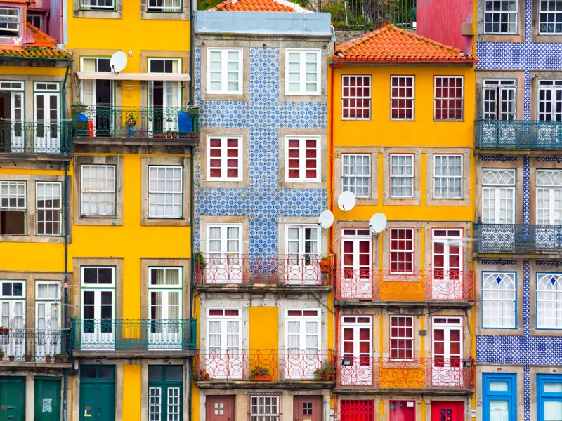 Dicht aneinandergereihte, farbenfrohe Häuserfassaden mit Azulejo-Kacheln in der Altstadt von Porto, UNESCO-Welterbe.