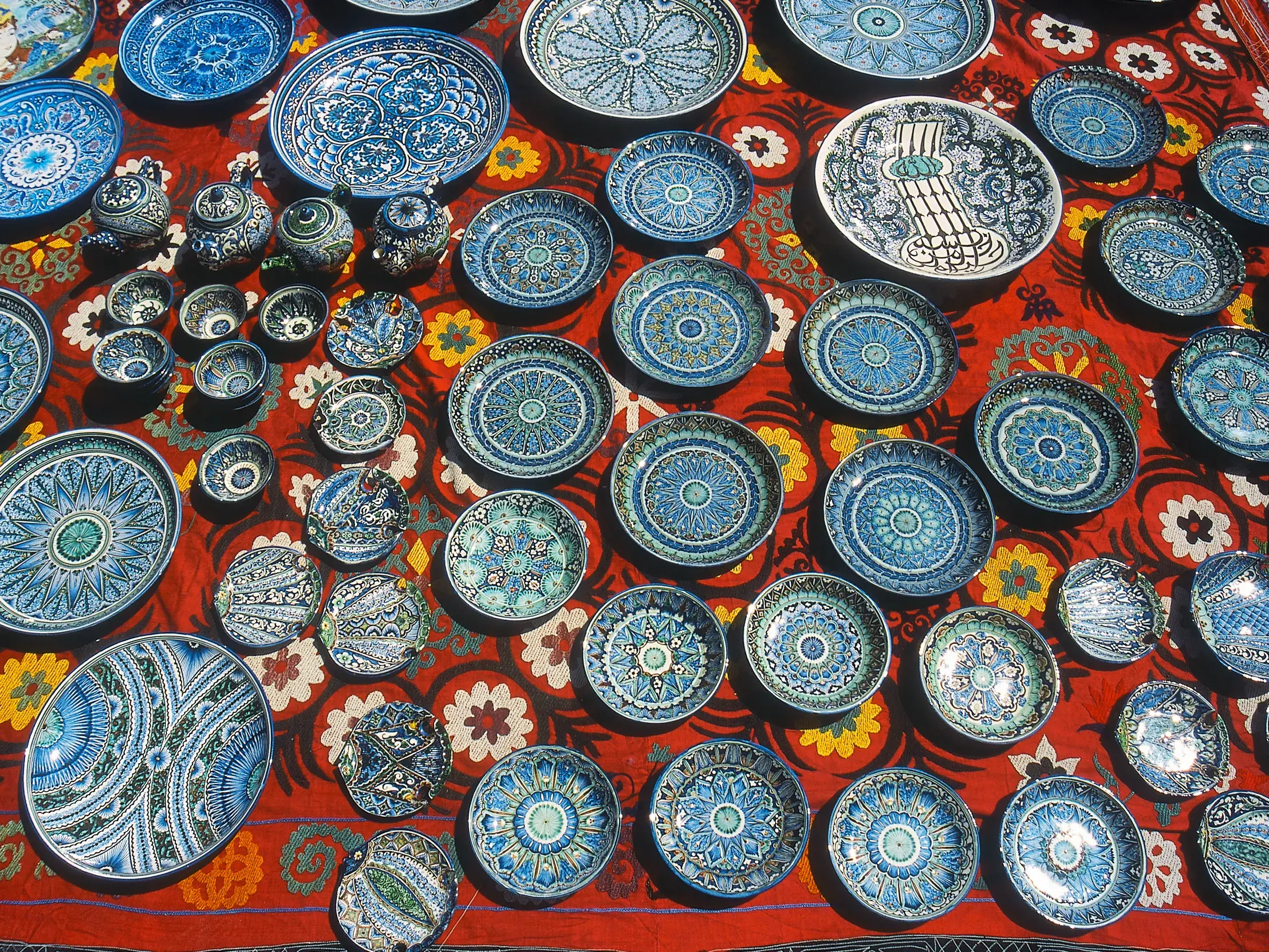 Bunte, handbemalte Keramikteller und Schalen mit blauen Mustern auf einem Markt in Usbekistan entlang der Seidenstraße.