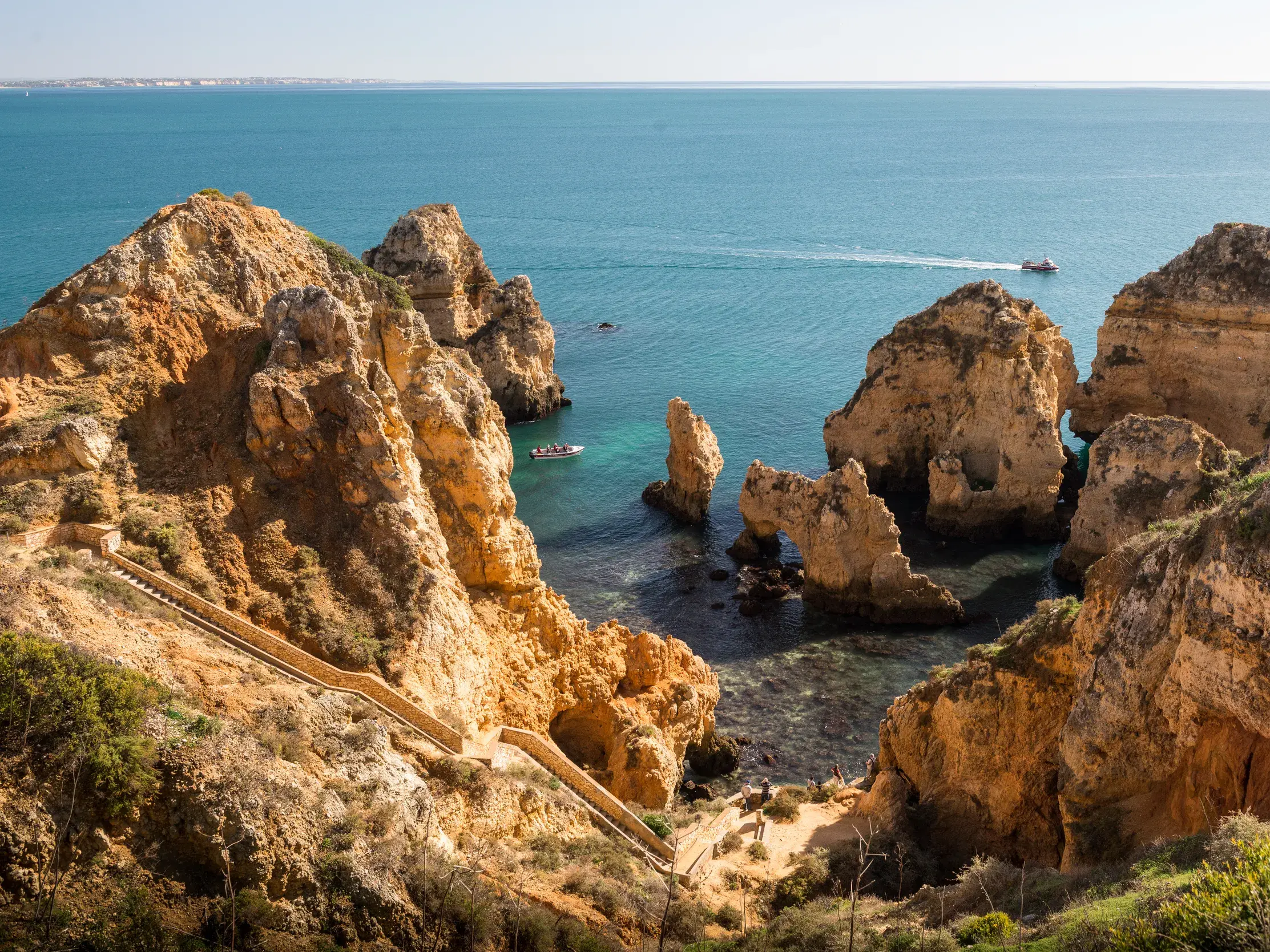Goldene Felsformationen der Ponta da Piedade ragen aus dem türkisen Atlantik an der Algarveküste nahe Lagos.
