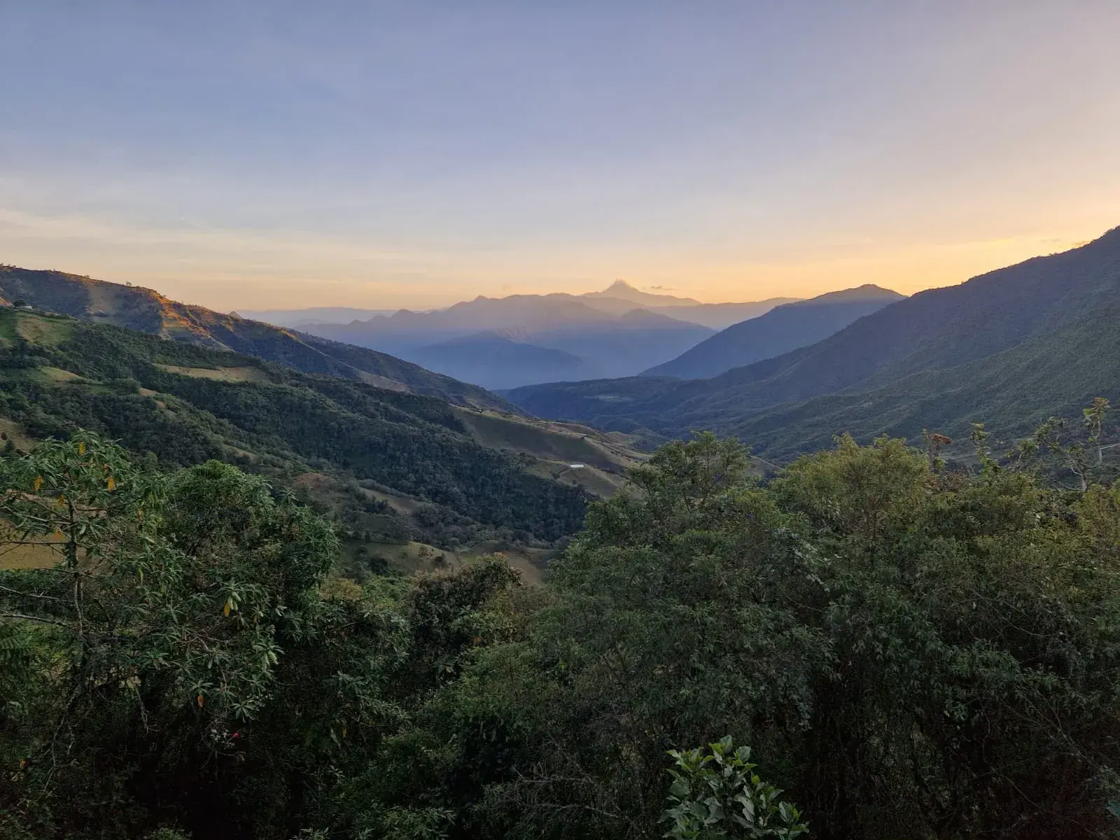 Abenddämmerung über einem grünen Tal der Anden in Ecuador mit Blick auf die Vulkane der Avenida de los Volcanes.