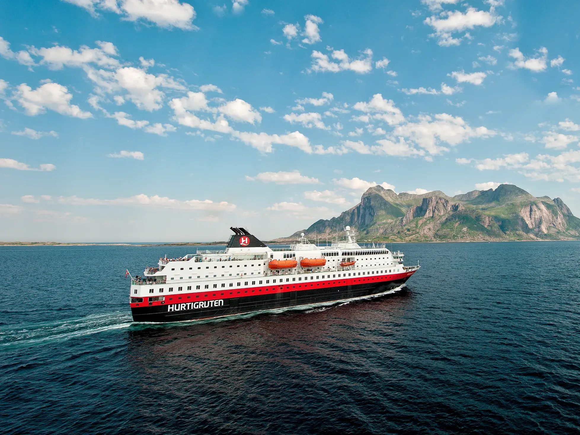 Das Hurtigruten-Postschiff MS Richard With gleitet bei sonnigem Wetter entlang der norwegischen Küste vor den Lofoten.