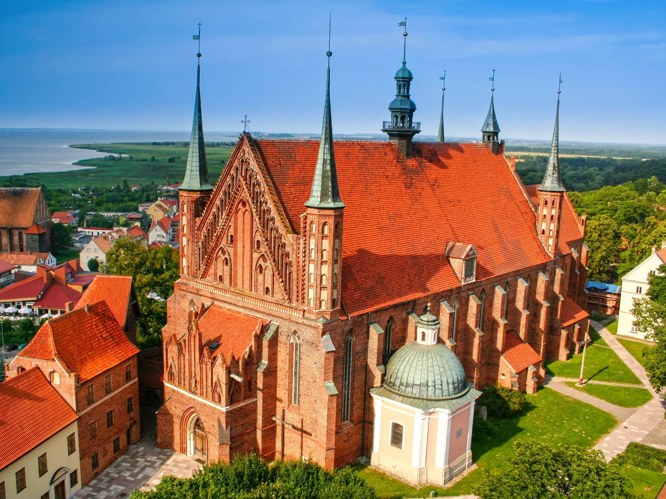 Luftaufnahme des gotischen Backsteindoms von Frombork (Frauenburg) mit Blick über die Stadt zum blauen Frischen Haff.