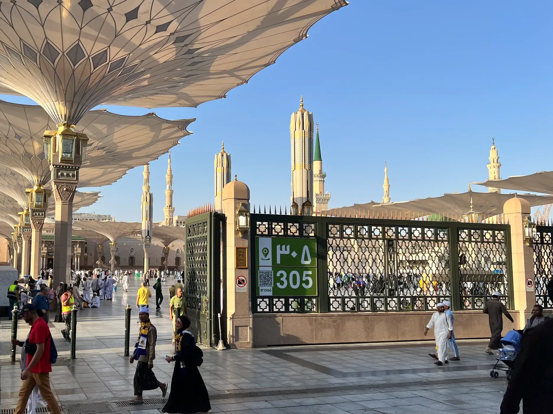 Besucher spazieren unter den gigantischen Sonnenschirmen auf dem Vorplatz der Prophetenmoschee (Masjid an-Nabawi) in Medina.