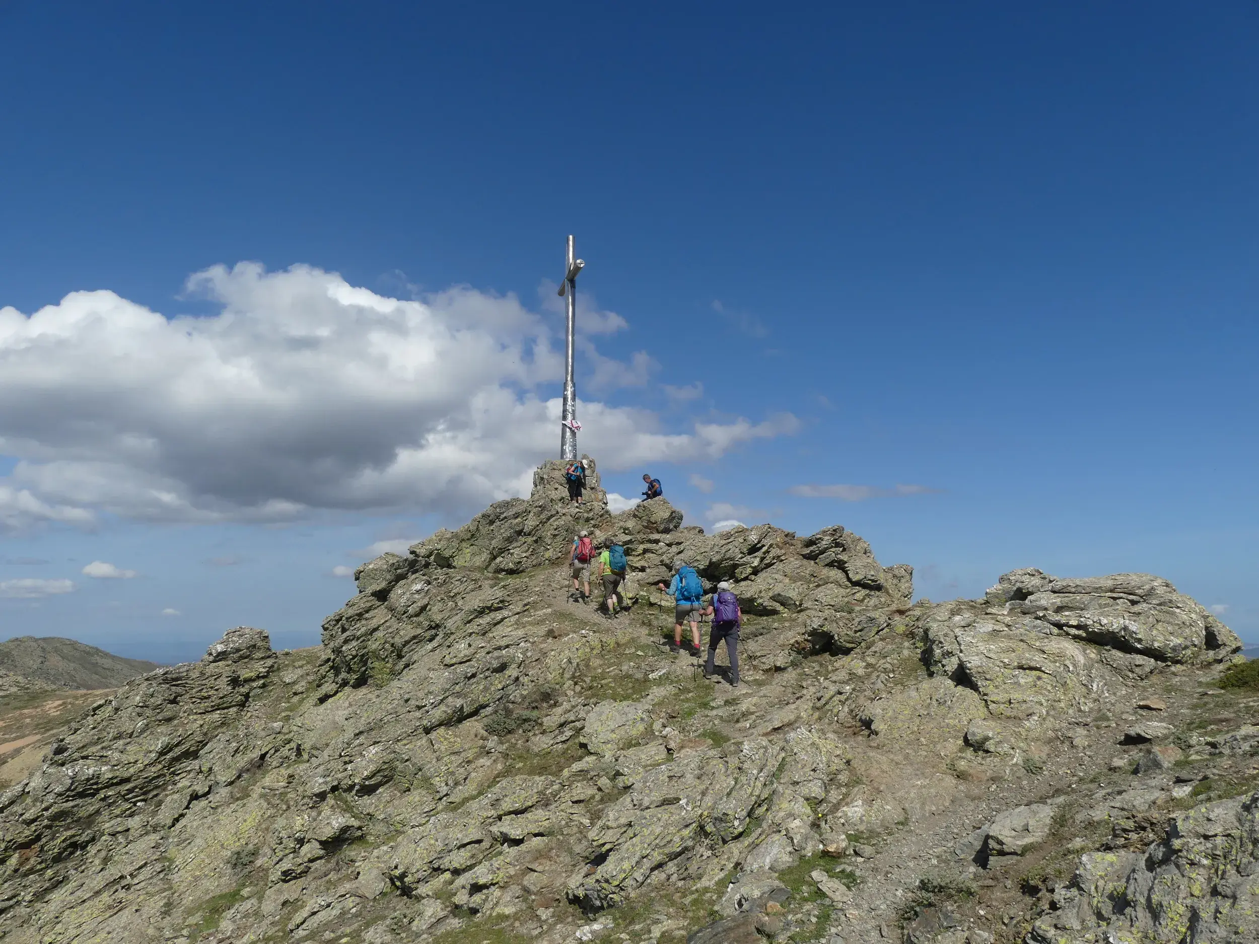 Eine Wandergruppe auf dem letzten felsigen Anstieg zum Gipfelkreuz der Punta La Marmora auf Sardinien.