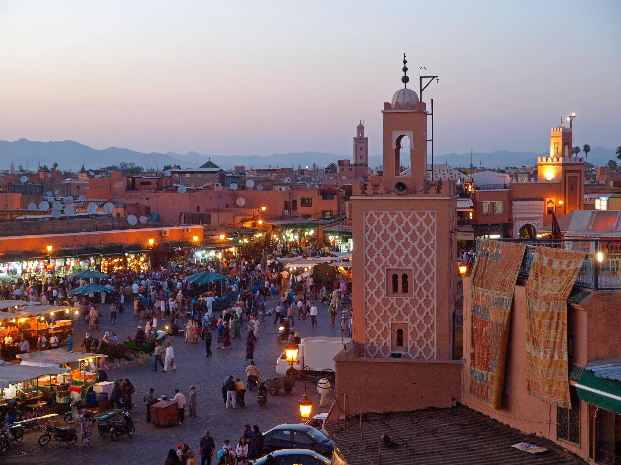 Blick über die Dächer auf den belebten Platz Djemaa el-Fna in Marrakesch, der auch "Gauklerplatz" genannt wird.