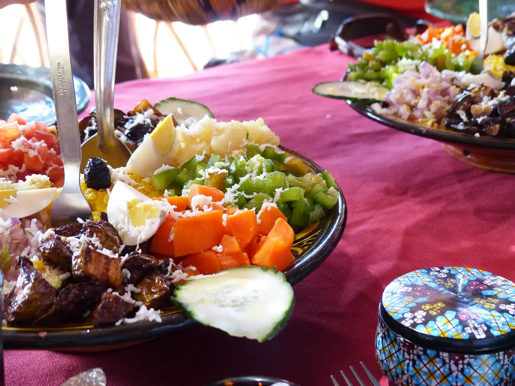 Bunter marokkanischer Gemüsesalat mit Ei, Karotten und Oliven, serviert als Vorspeise bei einem Kochkurs in Marokko.