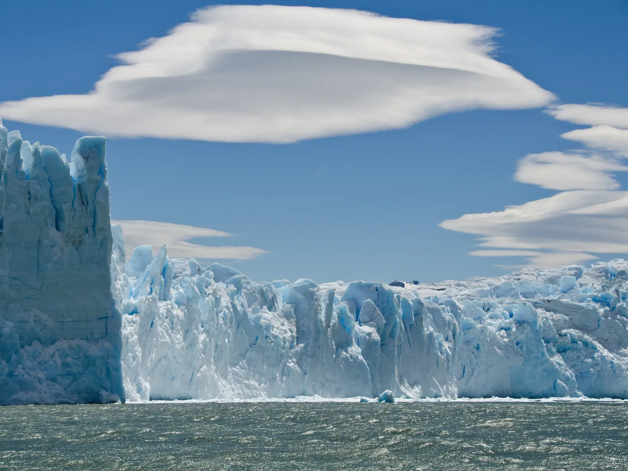 Majestätische Eiswand des Perito Moreno Gletschers im Los Glaciares Nationalpark in Patagonien unter blauem Himmel.