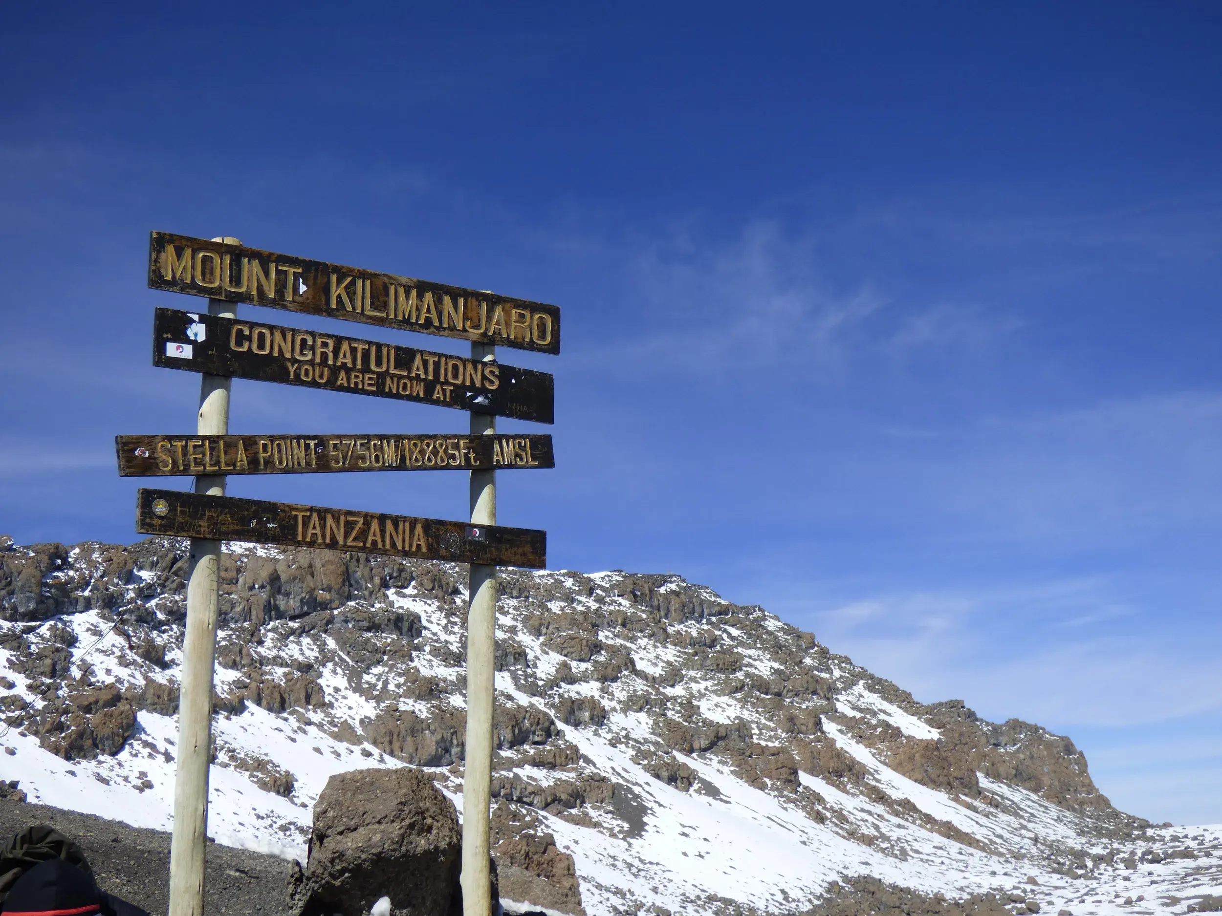 Das berühmte Holzschild am Stella Point auf 5756 Metern Höhe bei der Trekking-Tour auf den Kilimanjaro in Tansania.