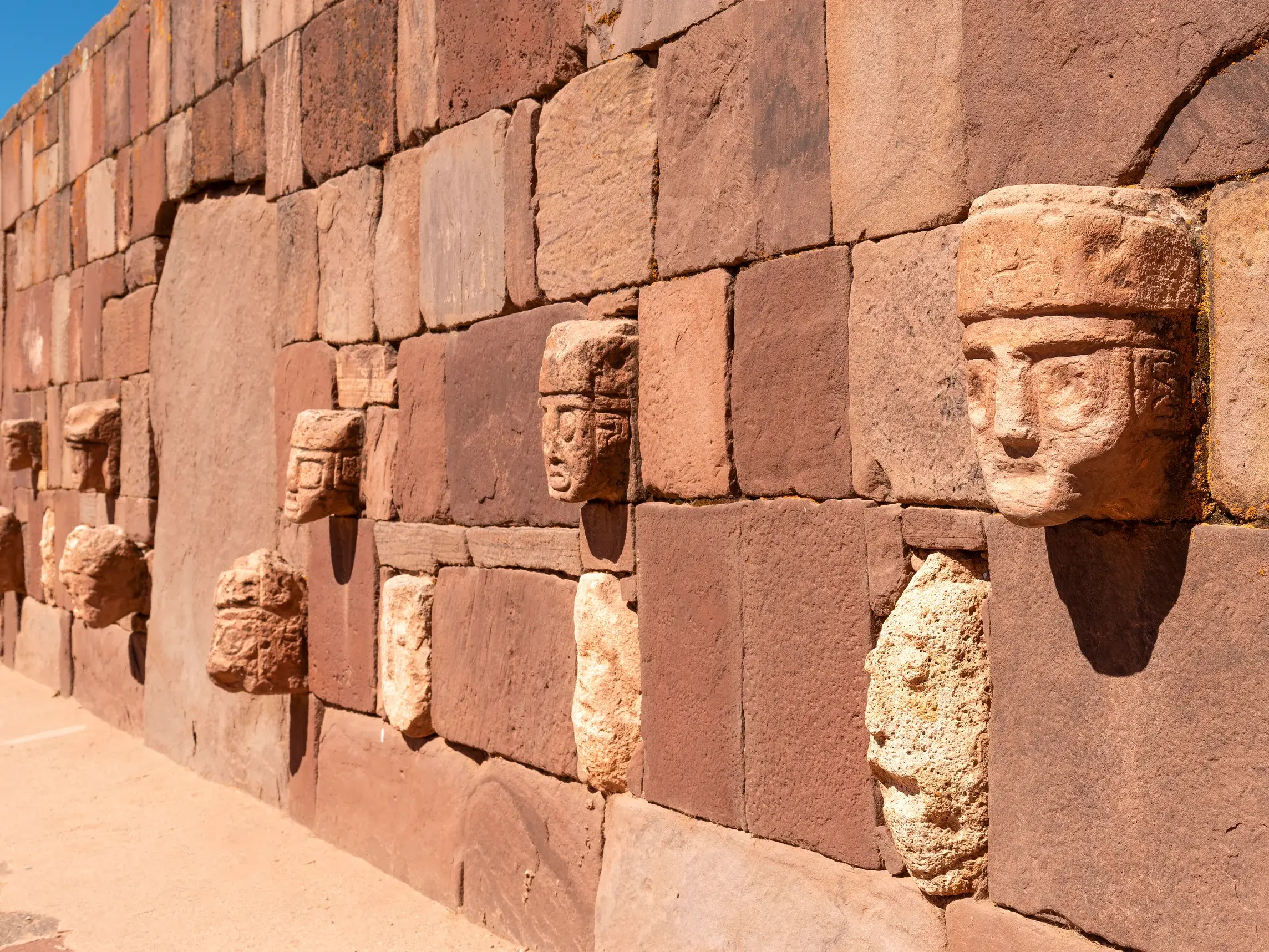 Die berühmte Mauer der Köpfe im versunkenen Tempel der UNESCO-Welterbestätte Tiahuanaco in Bolivien bei Sonnenschein.