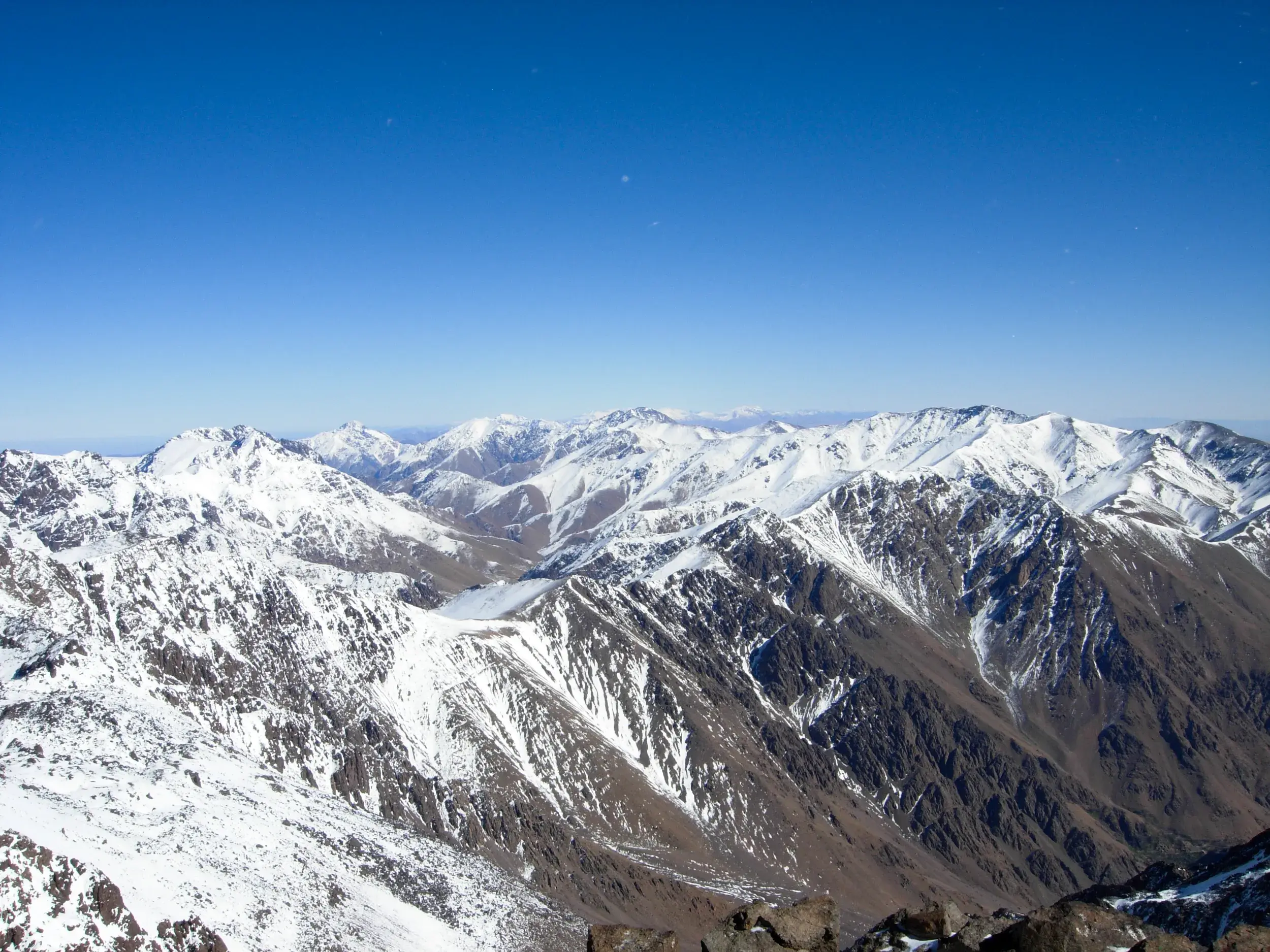 Spektakulärer Gipfelblick beim Winter-Trekking über das verschneite Toubkal-Massiv im Hohen Atlas in Marokko.