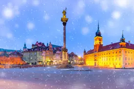 Der verschneite Schlossplatz in Warschau in der Dämmerung mit der Sigismundsäule und dem beleuchteten Königsschloss.