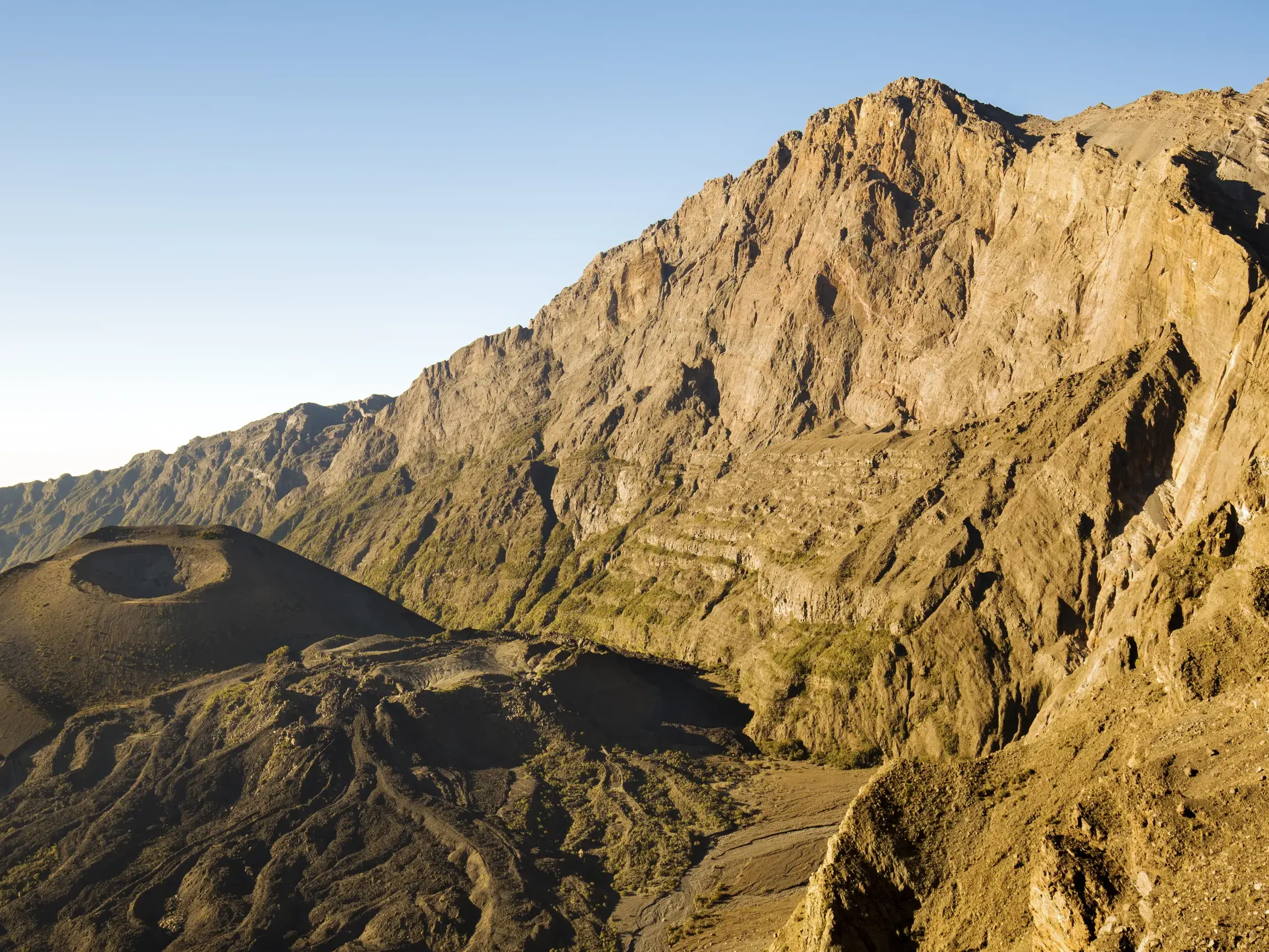Felsige Vulkanlandschaft des Mount Meru in Tansania mit dem Aschekegel im Krater, von der Morgensonne beleuchtet.