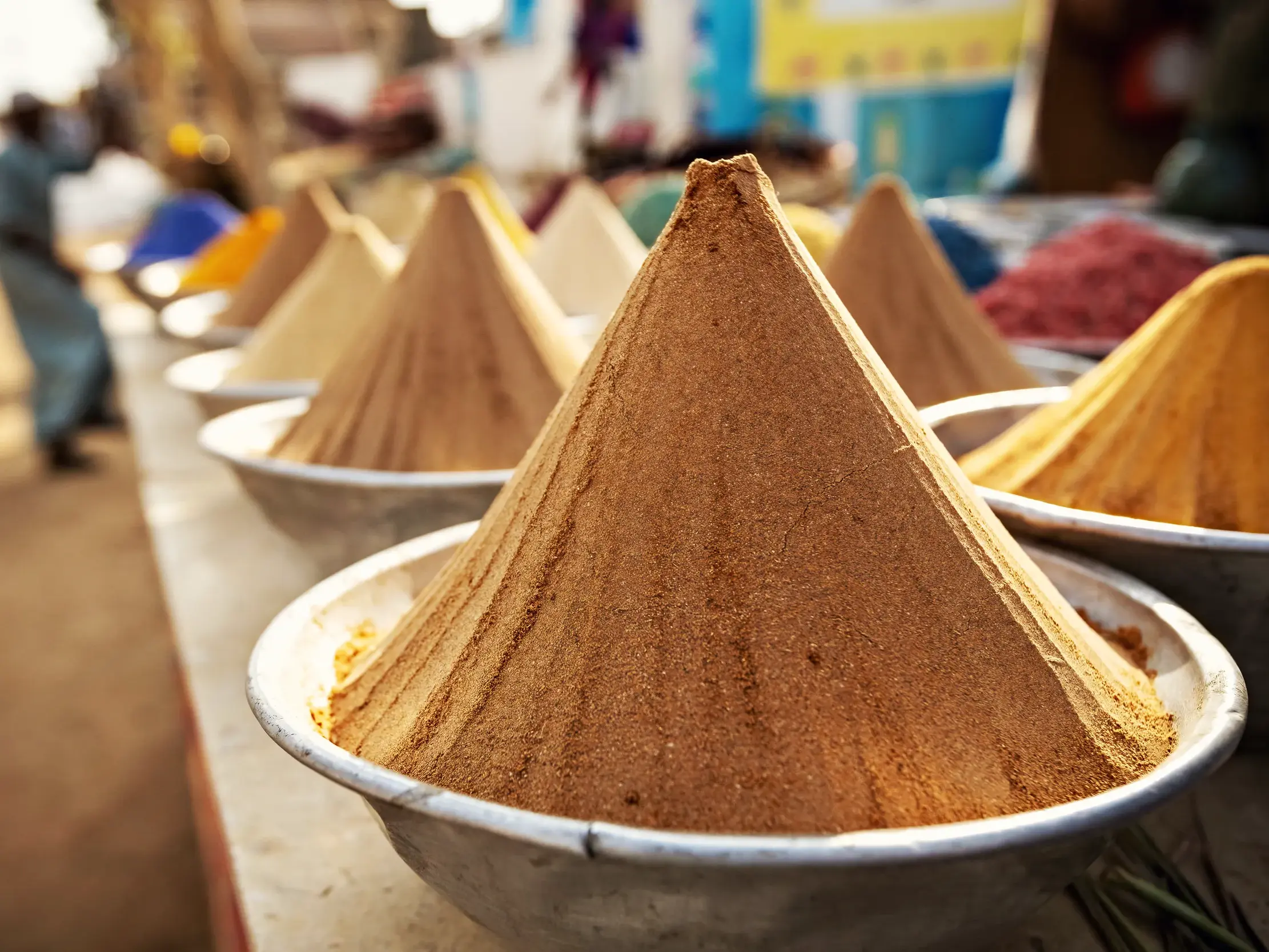 Nahaufnahme von zu Pyramiden geformten Gewürzen in Silberschalen auf dem belebten Khan-el-Khalili-Basar in Kairo.