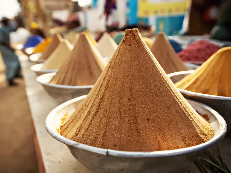 Nahaufnahme von zu Pyramiden geformten Gewürzen in Silberschalen auf dem belebten Khan-el-Khalili-Basar in Kairo.