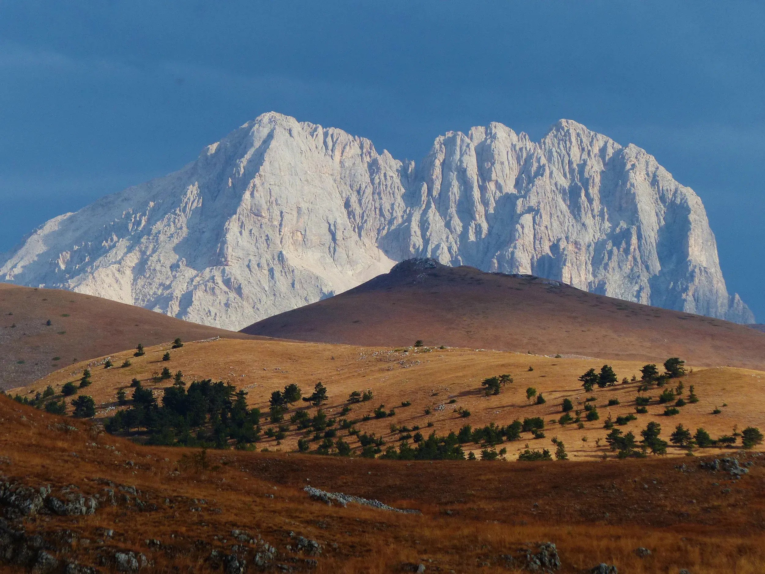 Panoramablick beim Trekking über die weite Hochebene Campo Imperatore zum imposanten Gran Sasso Massiv in den Abruzzen.