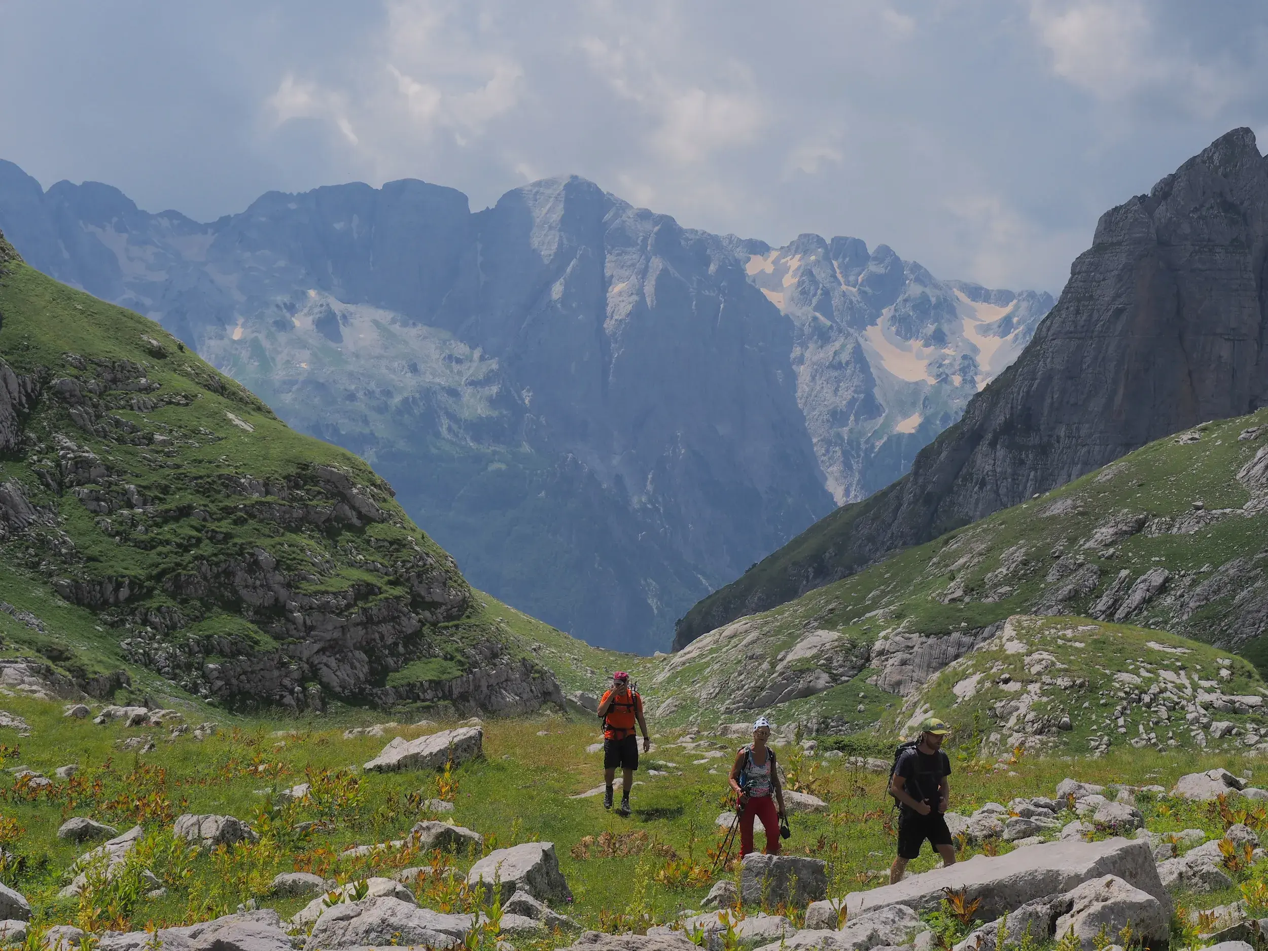 Hauser-Trekkinggruppe wandert über eine felsige Almwiese auf dem "Peaks of the Balkans"-Trail im Prokletije-Gebirge.