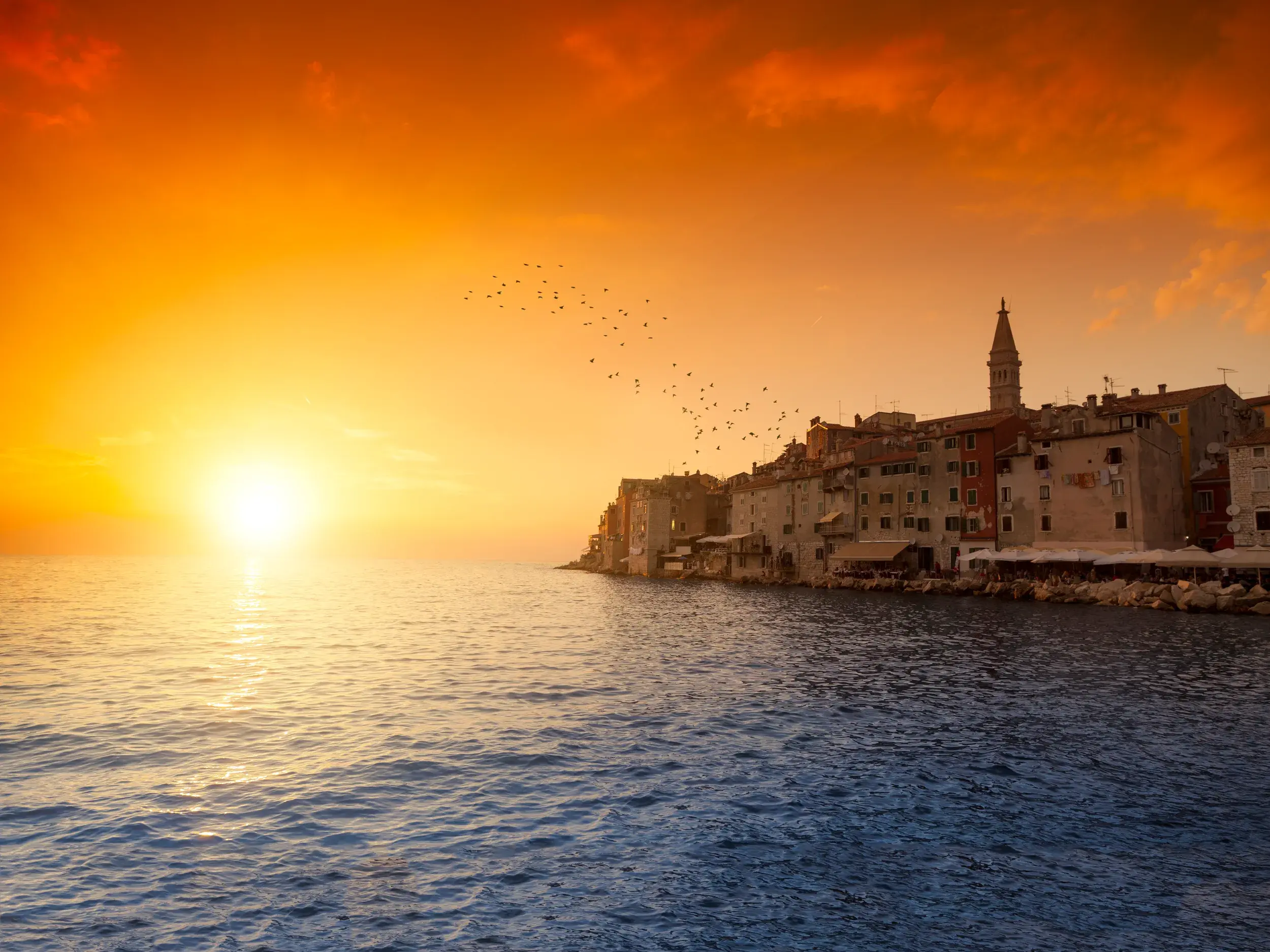 Malerischer Sonnenuntergang über der Altstadt von Rovinj in Istrien mit Blick auf die Euphemiakirche und die Adria.