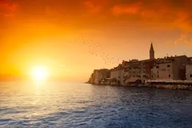 Malerischer Sonnenuntergang über der Altstadt von Rovinj in Istrien mit Blick auf die Euphemiakirche und die Adria.