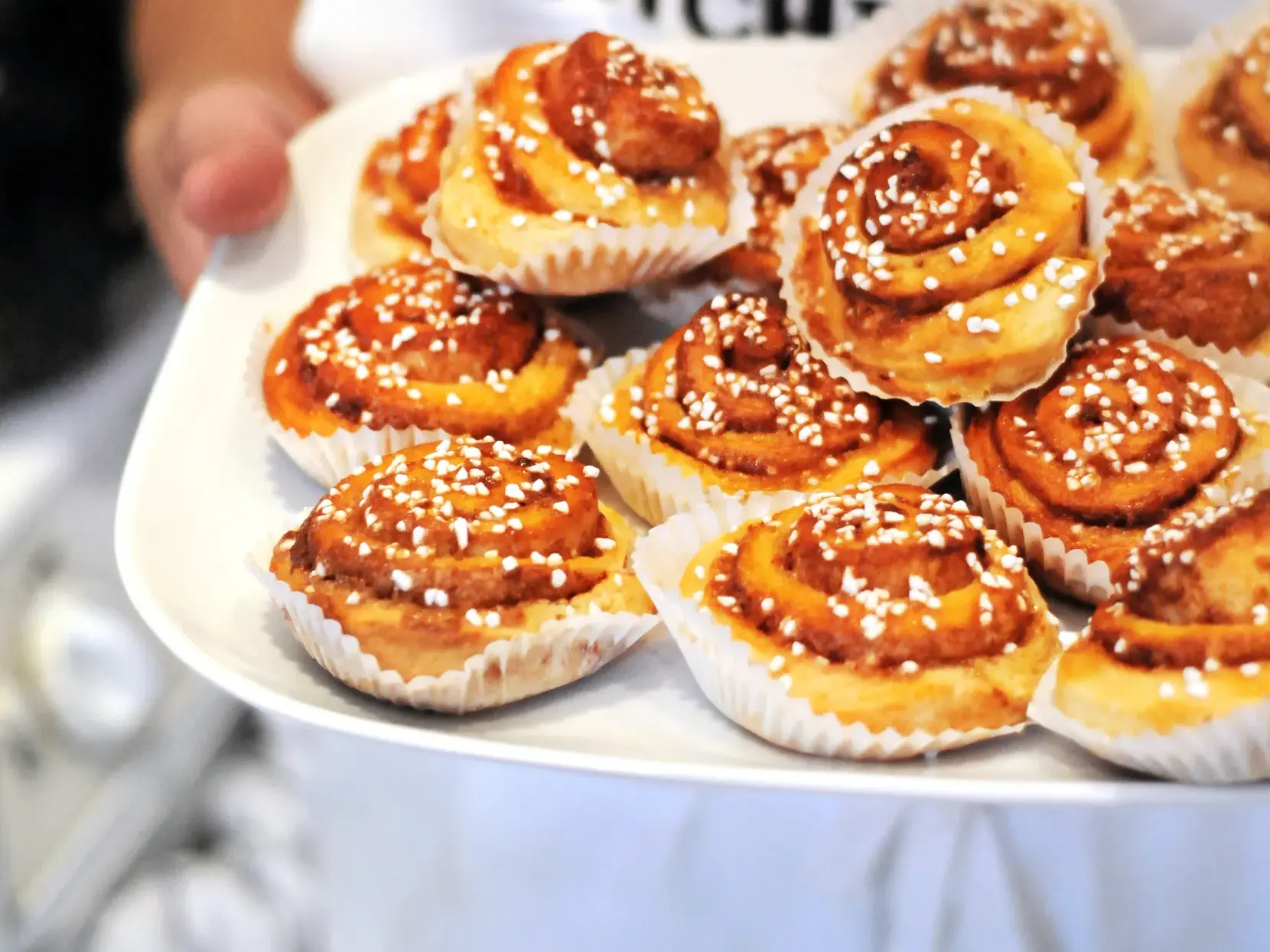 Ein Teller voller frisch gebackener schwedischer Zimtschnecken, Kanelbullar, die zur Fika-Kaffeepause serviert werden.