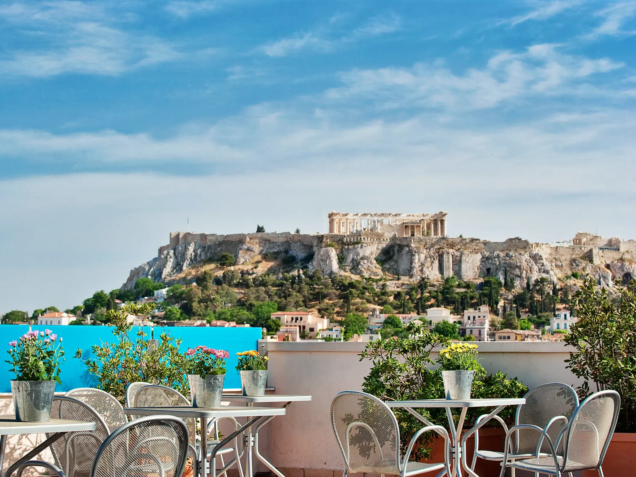 Blick von der Dachterrasse des Hotel Arion in Athen auf die historische Akropolis bei blauem Himmel.