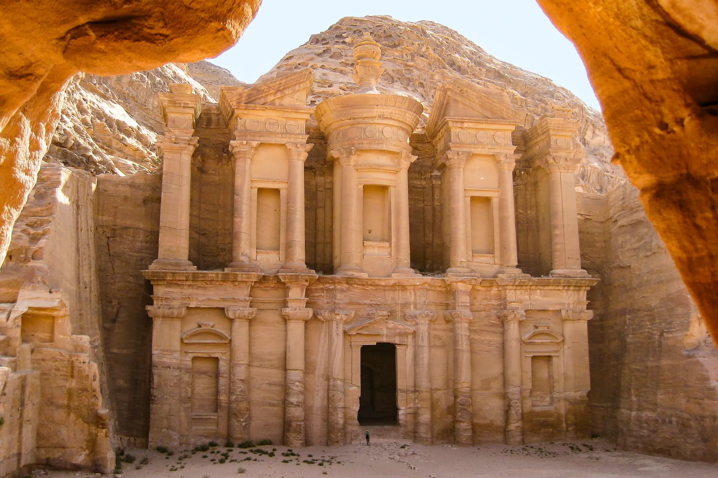 Einzigartiger Blick durch die enge Schlucht des Siq auf die monumentale, in Sandstein gehauene Fassade des Schatzhauses in Petra.