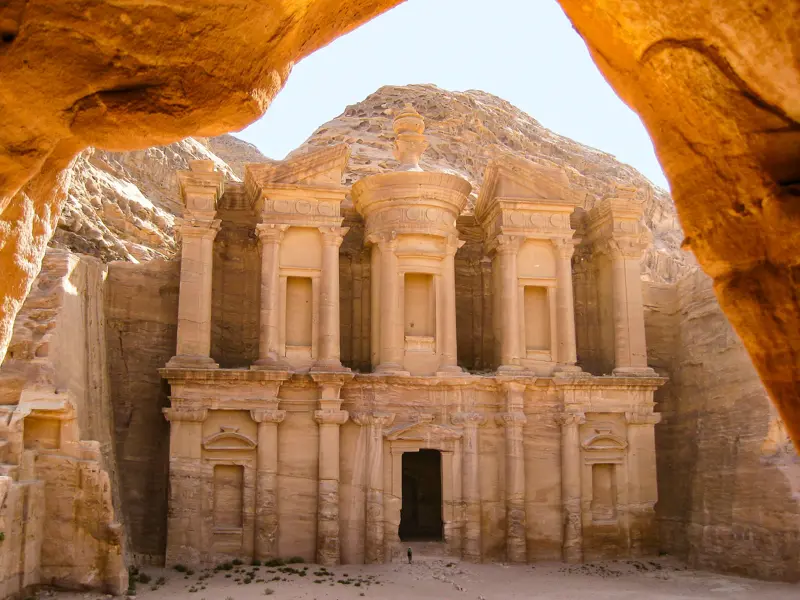 Einzigartiger Blick durch die enge Schlucht des Siq auf die monumentale, in Sandstein gehauene Fassade des Schatzhauses in Petra.