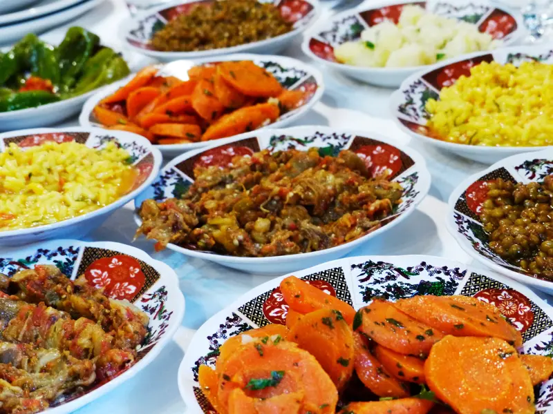 Bunte Auswahl marokkanischer Vorspeisen wie Karottensalat und Zaalouk, serviert in traditionell verzierten Keramikschalen.