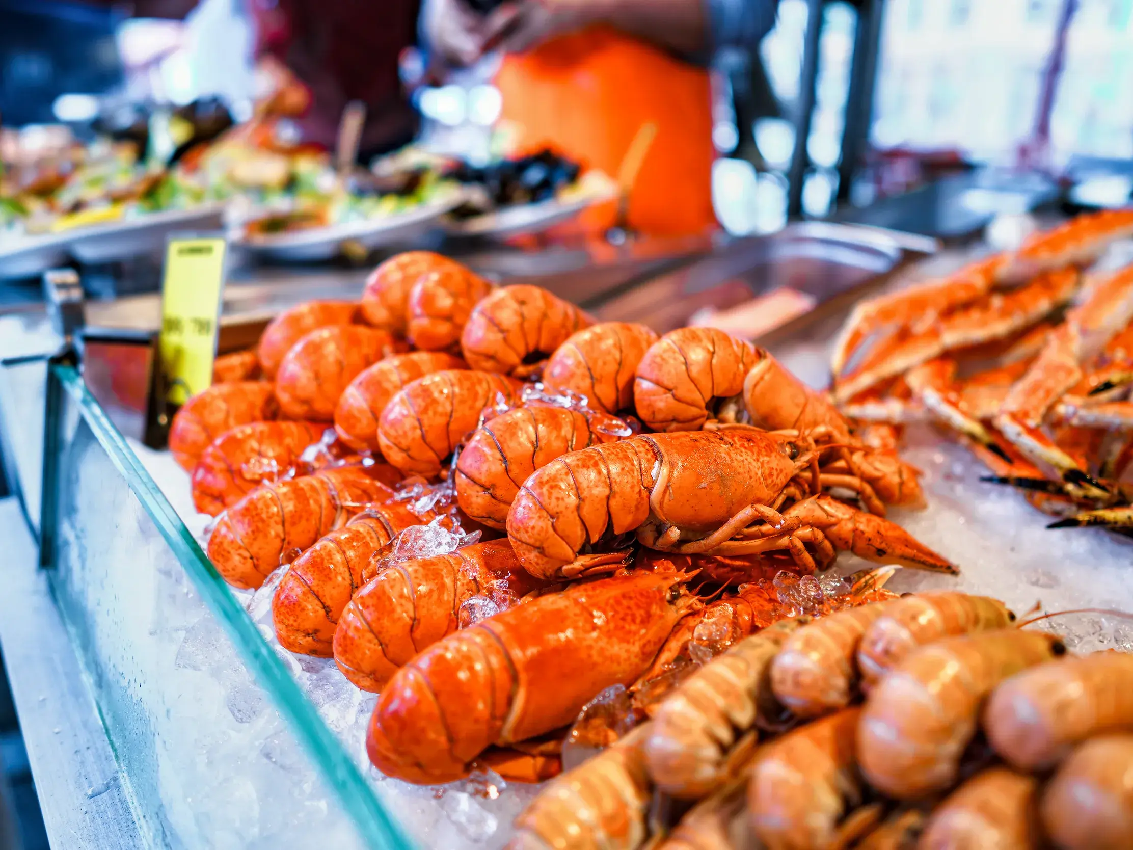 Leuchtend rote Hummer und Krabbenbeine als kulinarische Spezialität auf Eis in einer Marktauslage in Oslo.