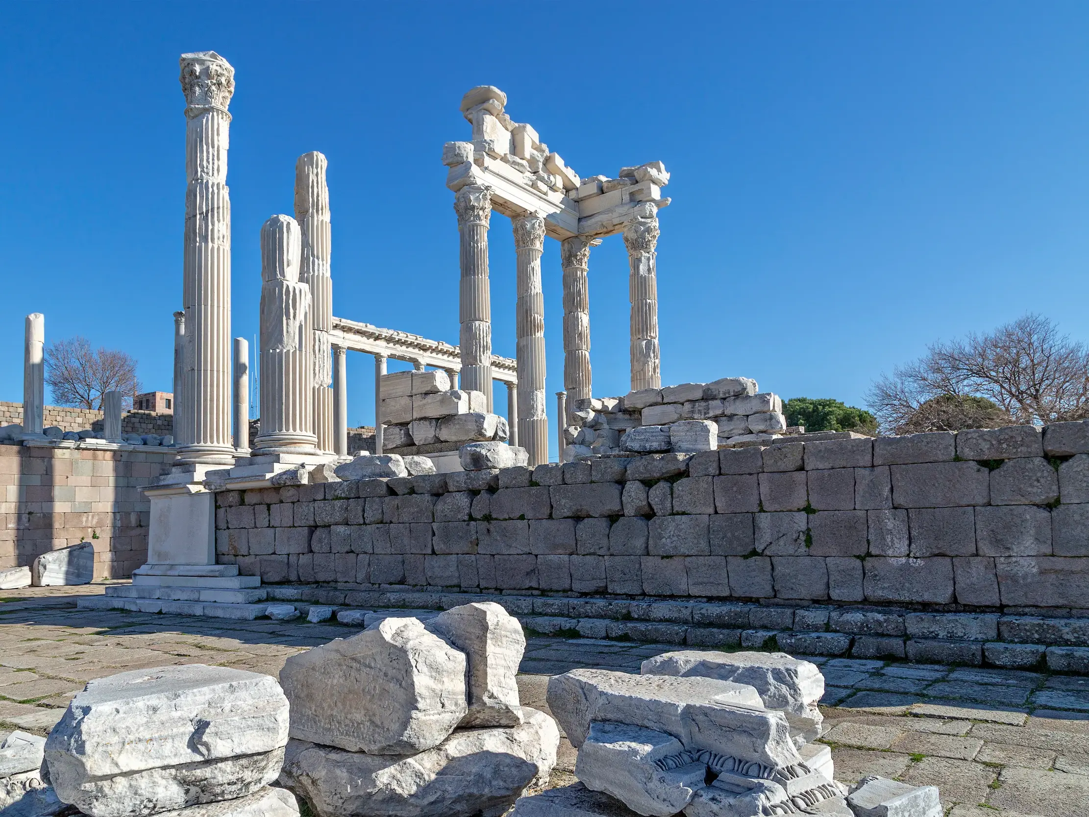 Imposante Marmorsäulen und Ruinen der antiken Stätte Pergamon, UNESCO-Welterbe in Bergama, bei strahlend blauem Himmel.