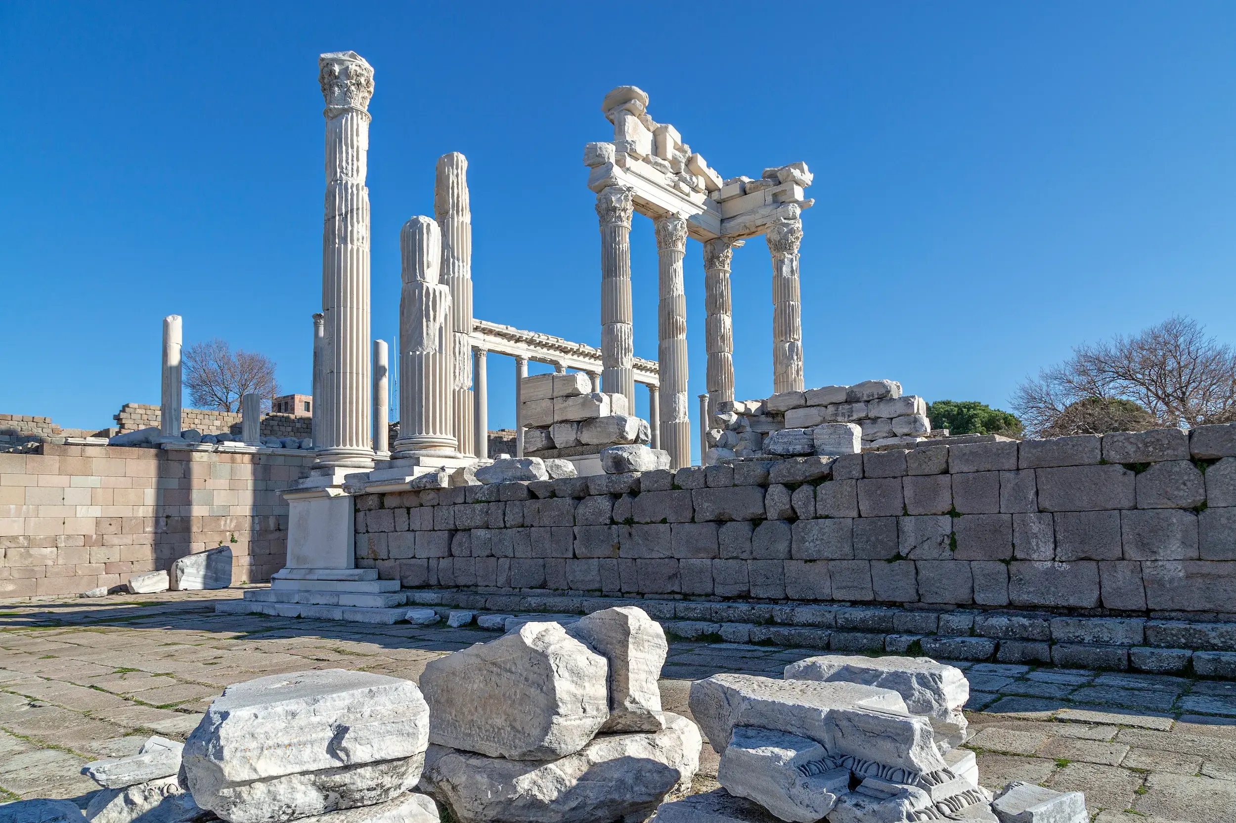 Imposante Marmorsäulen und Ruinen der antiken Stätte Pergamon, UNESCO-Welterbe in Bergama, bei strahlend blauem Himmel.