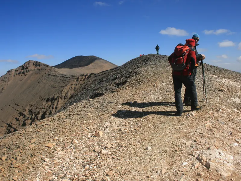 Trekkinggruppe auf dem schmalen Panoramakamm des Ighil Mgoun mit weitem Blick über das karge Mgoun-Massiv in Marokko.